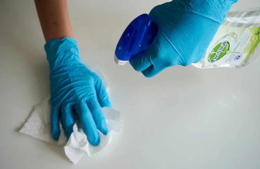 Gloved hands cleaning a surface, illustrating local services exploring ChatGPT advertising.